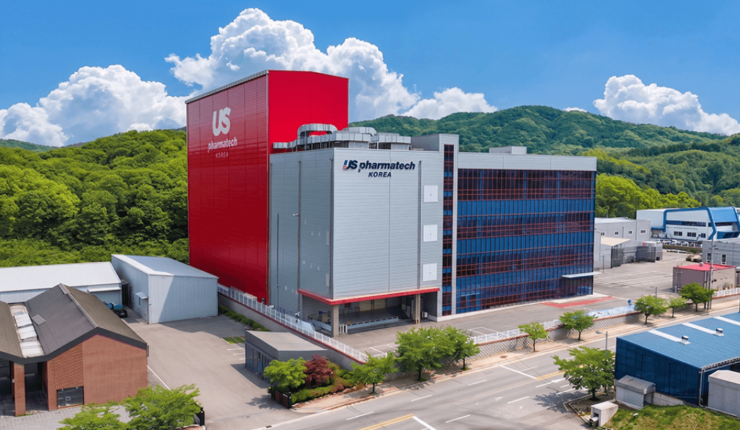 Factory exterior with surrounding roads and green hills